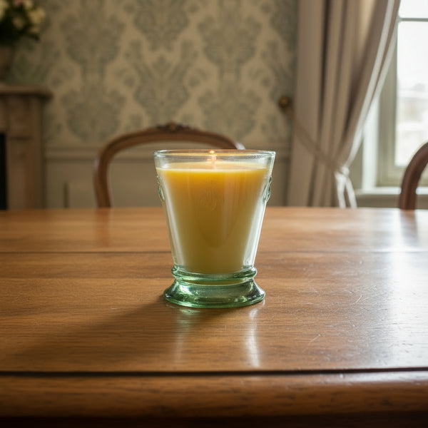 Bienenwachskerze im grünen Glas auf dem Tisch im Esszimmer