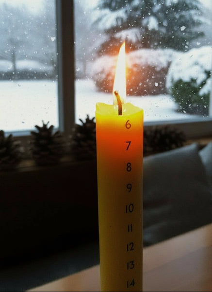 Adventskalenderkerze aus Bienenwachs angezündet