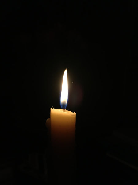 Tischkerze aus Bienenwachs angezündet