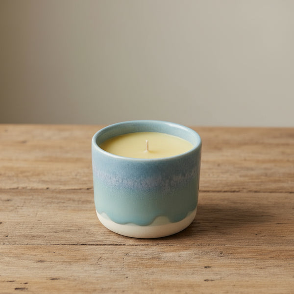 Bienenwachskerzen im blauen Keramikbecher auf dem Tisch