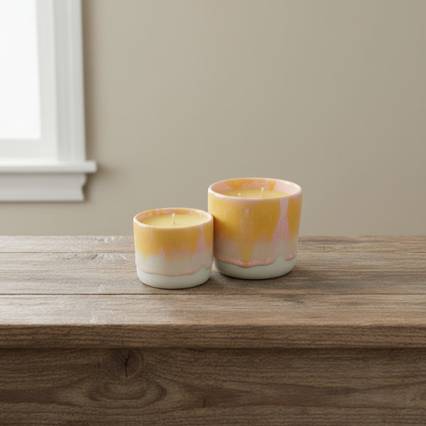 Bienenwachskerze im pinken Keramikbecher, groß und klein auf dem Tisch